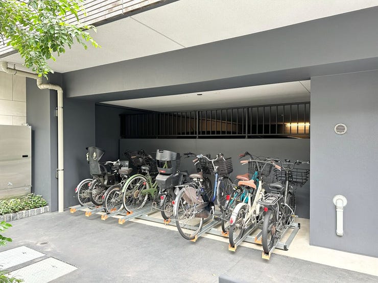 屋根付きで雨や日差しから大切な自転車を守る駐輪スペース。
スムーズに出し入れができるラック式を採用し、すっきりと整理できます。モダンな外観デザインに調和した、安心で利便性の高い共用設備です。