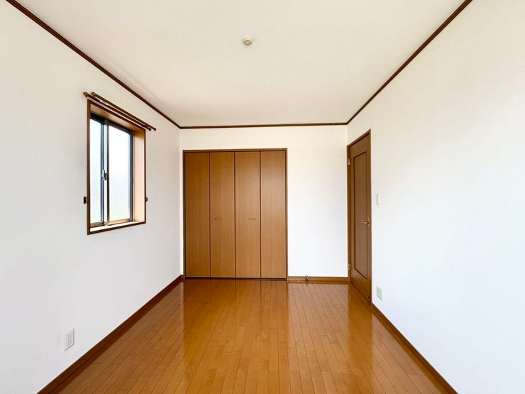 茶色の建具と白い壁紙で明るくも落ち着いた雰囲気の洋室。