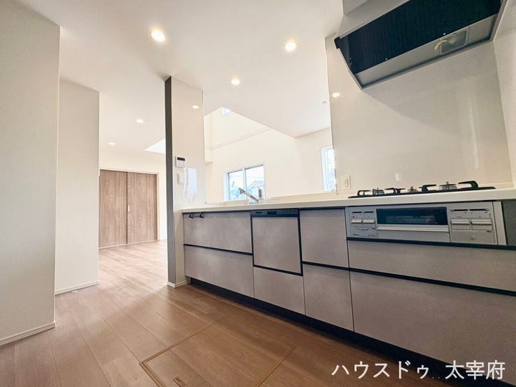 すっきりとしたモダンなシステムキッチン。広々としたカウンタースペースや便利なビルトイン食洗機を備え、家事効率が向上します。明るい木目調のフローリングと調和するスタイリッシュなデザインも魅力です。