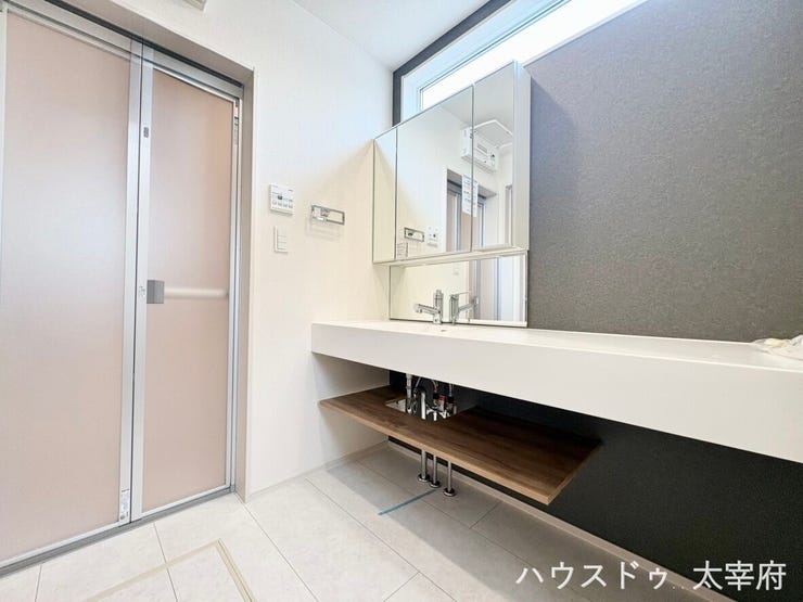 高窓からやさしい自然光が入る明るい洗面所。朝の身支度も心地よく、ダークグレーの壁面とスタイリッシュなカウンターが洗練された空間を演出します。