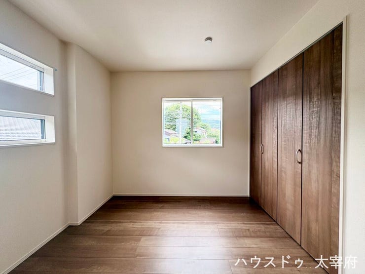 落ち着いた色合いのフローリングと木目調の大型クローゼットが魅力の洋室。二面採光で明るく、すっきりとした空間で快適に過ごせます。
