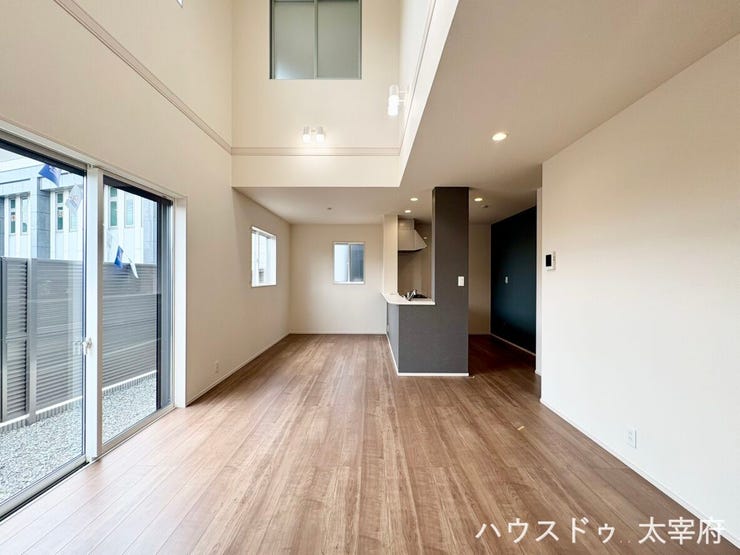 大きな吹き抜けと大きな窓が開放感抜群のリビングです。たっぷりの採光と明るい空間に加え、スッキリとした対面キッチンで家族のコミュニケーションも弾む快適な設計です。
