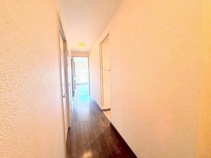 各お部屋をつなぐ廊下は、温かみのあるフローリングが特徴です。奥の部屋から差し込む自然光が広がり、家全体に明るい印象を与えます。段差も少なく、スムーズに行き来できます。
