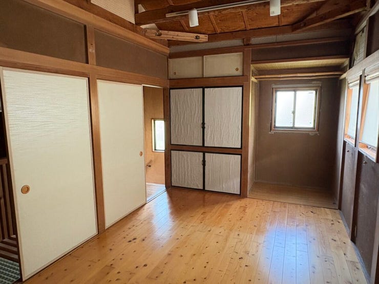 壁面収納を備えた、木の温もりを感じる和モダンな洋室です。押入れや収納棚が充実しており、お部屋をすっきりと広く使えます。窓からの柔らかな光が差し込む中で、家族のプライベート時間をゆったりと過ごせそうです
