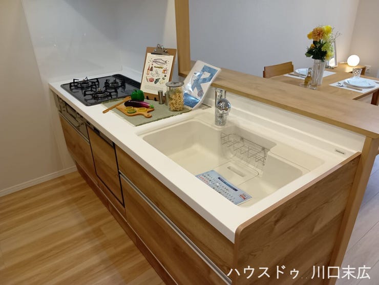 空間に優しく調和する木目調パネルを採用したシステムキッチン。作業スペースをしっかりと確保した機能的な設計で、毎日の調理や後片付けをスムーズにサポートします。