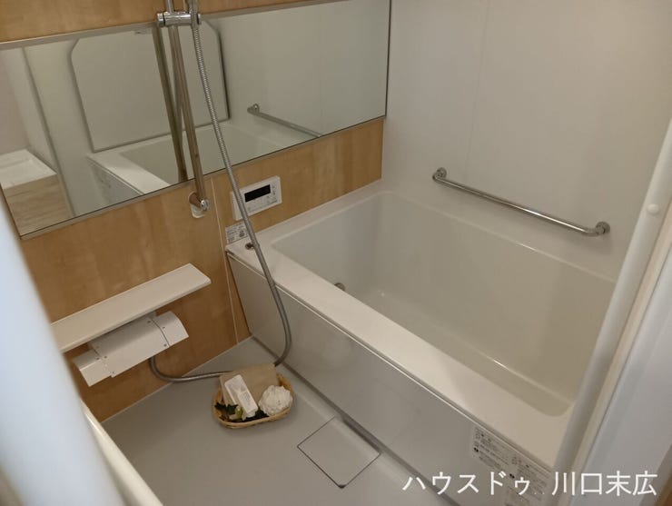 柔らかな木目調のアクセントパネルがリラックスタイムを彩るユニットバス。手すりを設けた安全設計で、ご家族全員が心地よく一日の疲れを癒やせる空間です。