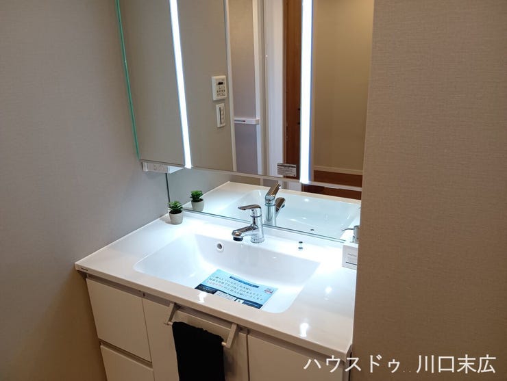 大きな鏡とスタイリッシュな照明を備えた洗面化粧台。継ぎ目のない一体型ボウルはお手入れがしやすく、清潔感あふれるサニタリー空間を維持します。