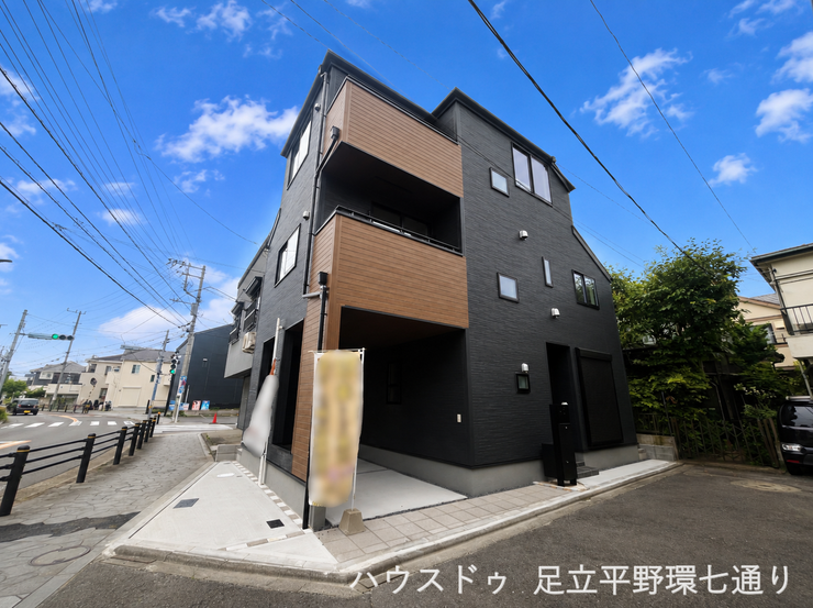 重厚感のあるダークカラーに木目調アクセントを取り入れた、スタイリッシュな3階建て。ビルトイン車庫付きの外観です。