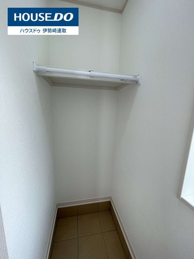 玄関横の便利な土間収納内部。上部棚とハンガーパイプ付きで、コート掛けや荷物置きに最適です。ベビーカーや外遊びグッズもそのまま収納可能!換気や採光に嬉しい小窓付きで、こもりがちな湿気対策も安心です。