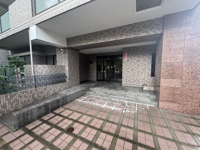 豊かな植栽と手入れの行き届いたエントランスが迎える9階建てレジデンス