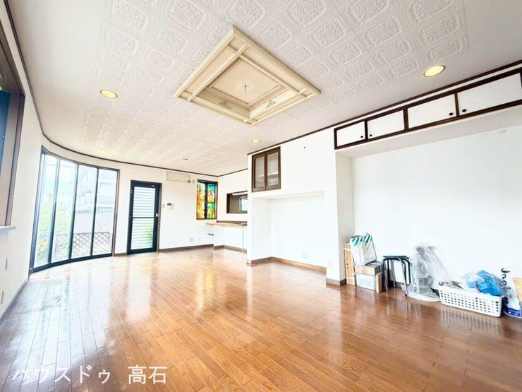 緩やかなアール(曲線)を描く大開口の窓はデザイン性が高く、外からの光を立体的に取り込めます。
奥の壁面にカラフルなガラスがはめ込まれており、外光が差し込むとリビングに美しい色彩が広がります。