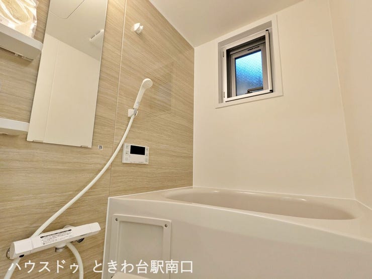 窓付きで換気もしやすい浴室。木目調のパネルが落ち着いた雰囲気を演出し、一日の疲れを癒すひとときを提供します。