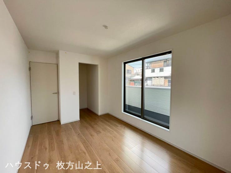 バルコニーに面した大きな窓から明るい陽光が差し込む洋室です。