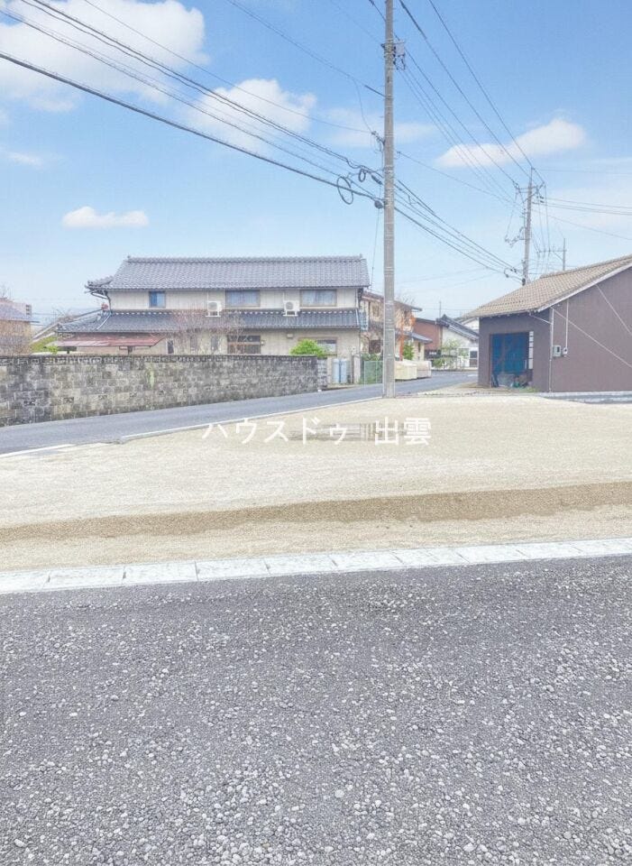東側位置指定道路から見た現況外観写真です。コンクリート敷き駐車場部分へはこちら側から進入できるようになります。