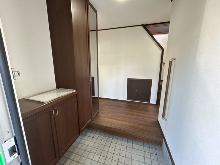 玄関ホールです。壁のクロス張替え、照明交換とホールの床はフロアを張ってきれいに仕上げました。