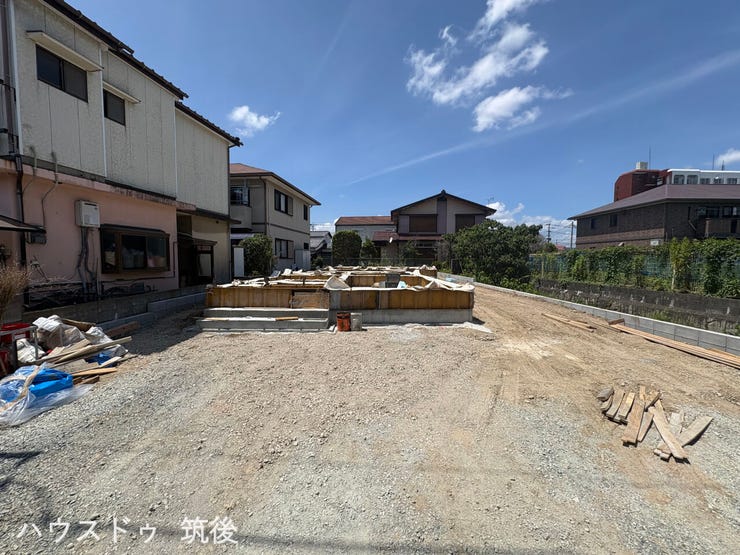 全2棟の手前側に位置する2号棟の現地写真です。南東側の前面道路に面しており、お車の出し入れや駐車がスムーズに行える並列2台分のカースペースを確保。日々の生活や通勤にも便利な配置が魅力です。