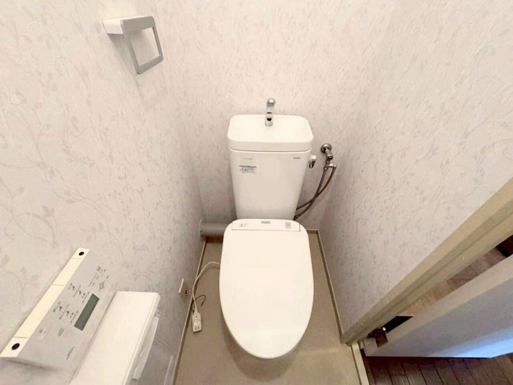 清潔感のある落ち着いた柄のクロスを採用したトイレ空間です。温水洗浄便座を備えており、毎日のご利用も快適です。壁付けのリモコンで操作もしやすく、使い勝手に配慮された設計となっています。