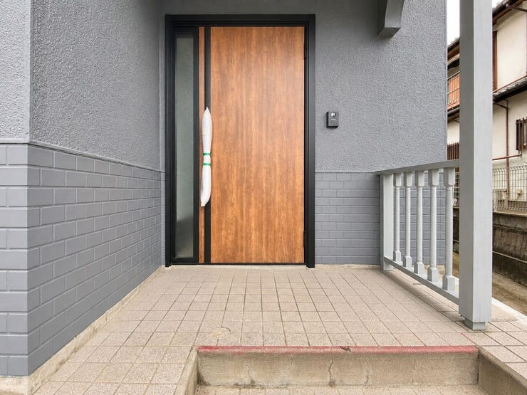 木目調の玄関ドアが温かみを演出。屋根付きのため、雨の日も落ち着いて出入りできます♪
