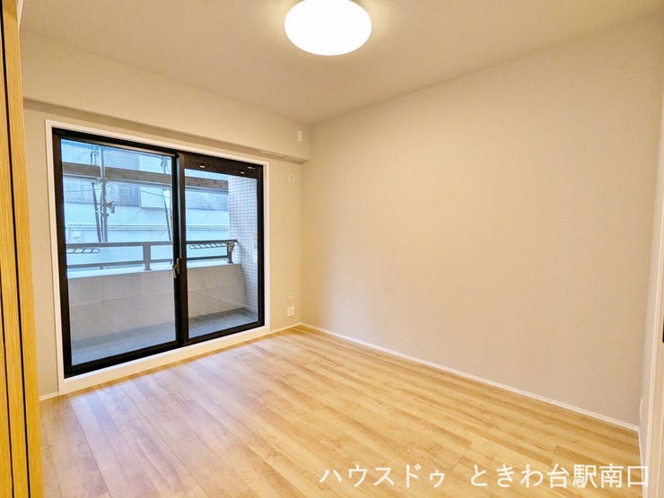 【洋室5.7帖】木目調の床が温かみを感じさせる居室。ウォーキングクローゼットもあり、すっきりと整理して使えるシンプルな間取りです。※2026年10月まで大規模修繕工事中のため足場が組まれています。