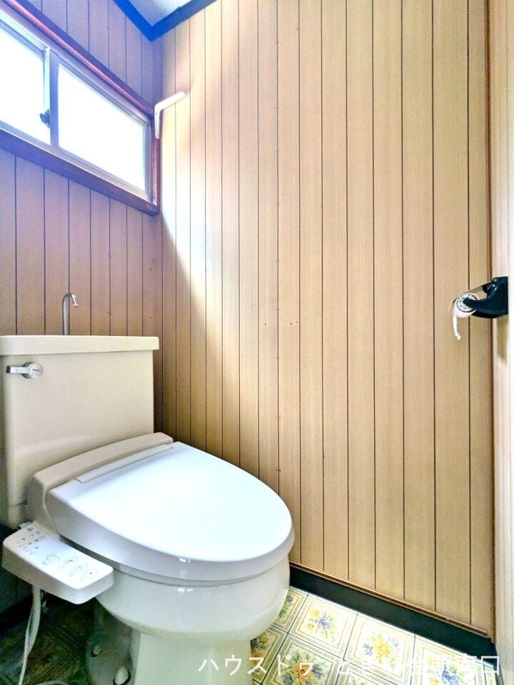 木目調の壁紙で温かみのあるトイレ。温水洗浄便座付きで、毎日を快適に過ごせる設備が整っています。