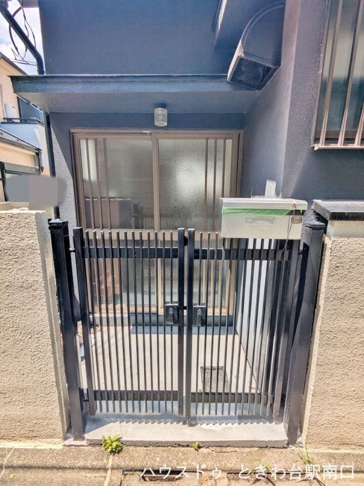 シンプルな門扉とポストが設置された玄関口。コンパクトながら、住まいの顔として整った印象を与えてくれます。