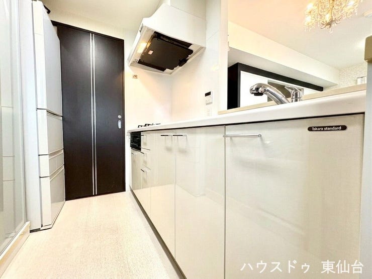 キッチンの奥は洗面所につながる、家事ラク動線です※AIによる画像処理を施しています(家具・小物消去)