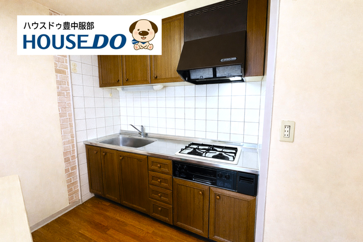 壁付で動線が整ったキッチン。3口コンロと豊富な収納、吊戸棚が揃い、機能性と美しさを両立した使いやすいスペースです。