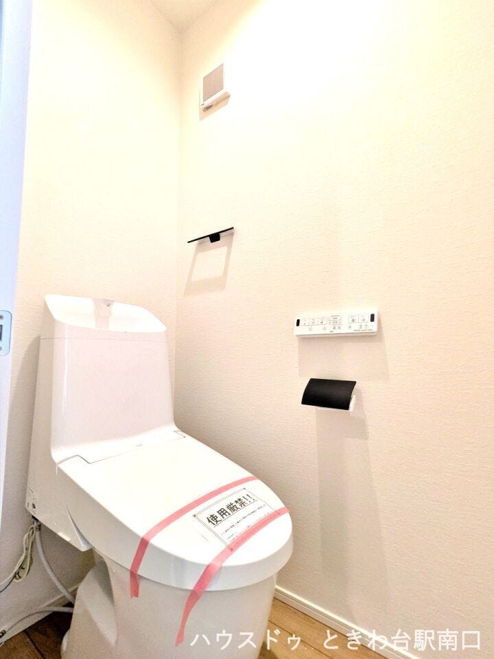 スッキリとしたデザインの温水洗浄機能付きトイレ。操作しやすい壁掛けリモコンや、お手入れのしやすいシンプルな形状が、清潔で心地よいプライベート空間を維持しやすくしています。