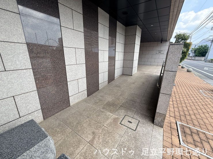 雨の日も出入りしやすい屋根付きのアプローチ。落ち着いた石調のデザインが上質な印象を与えます。