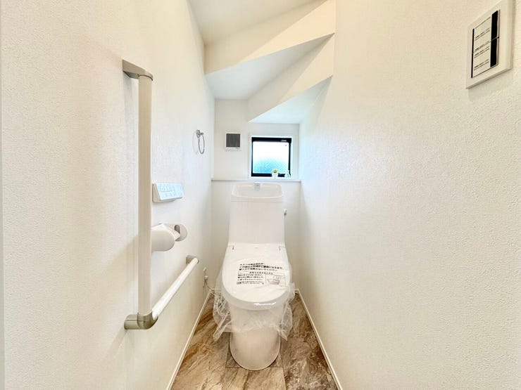 手すり付きで安心して使える、清潔感のあるトイレ空間。