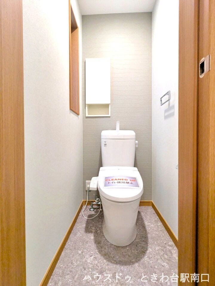 清潔感のある温水洗浄便座付きのトイレ。上部には小物をすっきり整理できる吊戸棚が設置されており、機能的です。