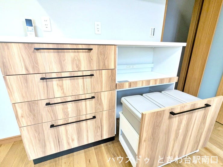 キッチン背面には、機能的なカップボードを完備しています。下部にはゴミ箱を収納できるスペースが設けられており、生活感を抑えながらキッチン周りをすっきりと整頓することが可能です。