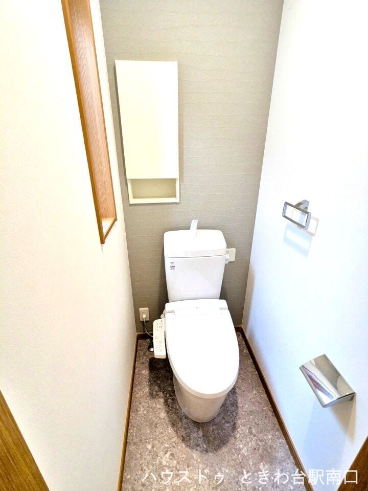 落ち着いた雰囲気のトイレ空間には、便利な温水洗浄便座を採用。壁面には小物の整理に役立つ収納棚を設けており、空間をスッキリと保つことができます。