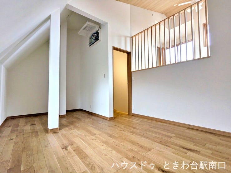 高い天井と木の格子が印象的なリビング空間です。スキップフロアを活かした立体的な間取りにより、空間に奥行きと家族の繋がりを感じられる住まいになっています。