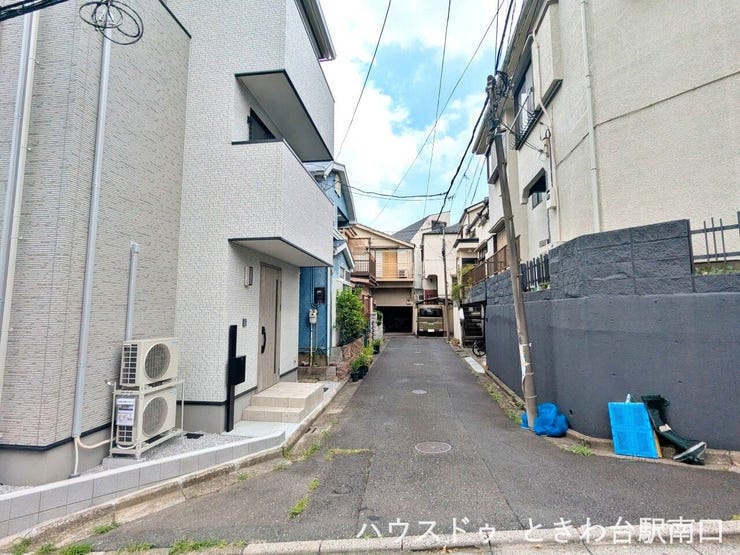 玄関へと続く落ち着いたアプローチです。第一種中高層住居専用地域に位置しており、静かで穏やかな生活空間が守られています。周辺施設へのアクセスも良好です。