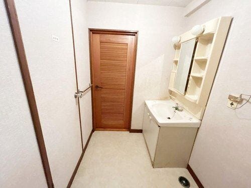 洗面脱衣所の写真です。クロス張替、CF張替、照明器具設置、洗面化粧台の交換を行なう予定です。