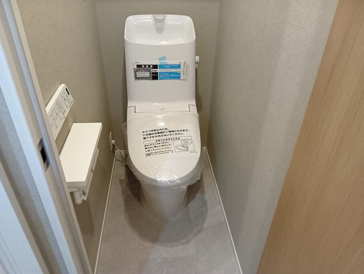 手洗い機能を備えた温水洗浄便座付きのトイレ空間。凹凸の少ないプレーンなフォルムで、日々の拭き掃除などのメンテナンスもスムーズに行えます。