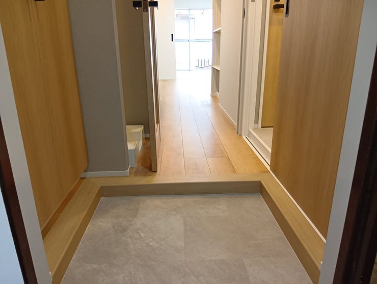 居住空間へと続く、木目の質感が美しいフローリングを採用した廊下。段差を抑えたフラットな設計で、日々のスムーズな生活動線を確保します。
