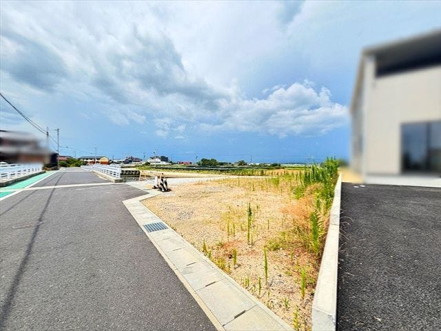 前面道路を含めた現地の様子です。車の出入りや建物配置もイメージしやすく、周辺には田園風景が広がる穏やかな住環境が魅力です。