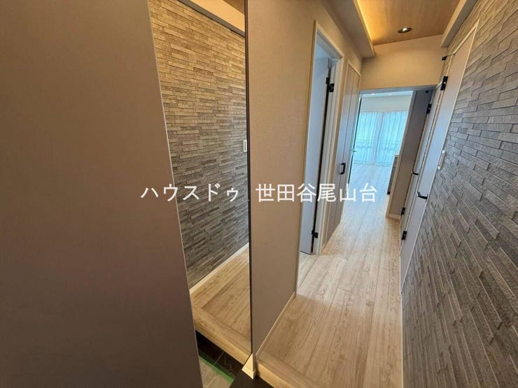 アクセントウォールと間接照明が上質な印象を演出する玄関。姿見付きでお出かけ前の身だしなみ確認も便利。リビングへ続く開放的な動線が住まいの魅力を高めます。
