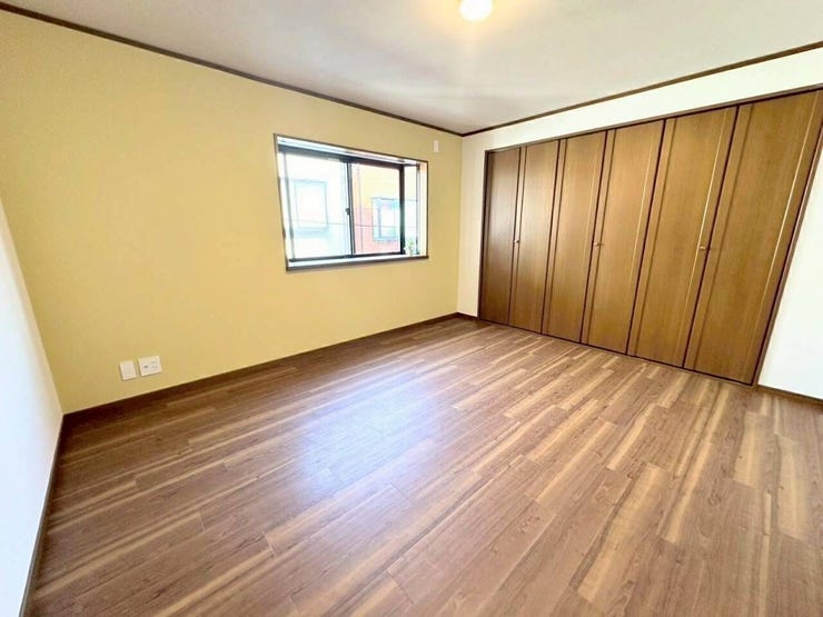 外からの光が程よく入り込む角部屋仕様の洋室です。窓辺からは周囲の落ち着いた景色が見え、日中の明るい時間帯には照明を控えめにしても、自然の明るさの中で心地よく読書や作業が行えます。