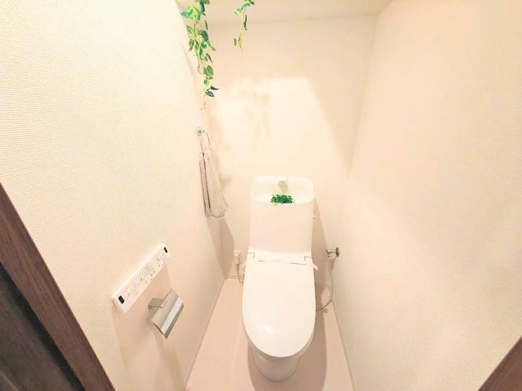 温水洗浄便座付きで快適なトイレタイム。壁掛けリモコンで操作もスムーズです。壁一面の棚はトイレットペーパーや芳香剤のストックに重宝。いつでもすっきりとした空間を保てます。