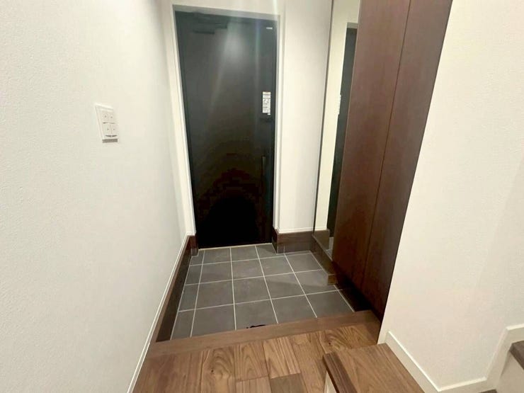 出かける前の身だしなみチェックに便利な大型の鏡付き収納を設置。玄関タイルは汚れが目立ちにくい落ち着いた色合いを採用し、日々のお手入れを楽にする機能的な設計です。