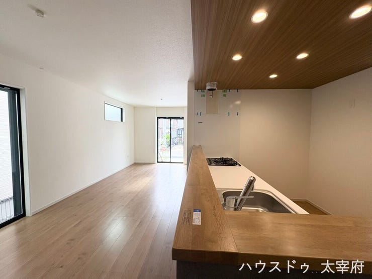 明るく開放感のあるフローリングのLDKに、木目調の下がり天井と間接照明がアクセントになったおしゃれな空間です。リビング全体を見渡しながら調理や家族との会話を楽しめます。