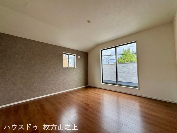 アクセントクロスが映えるおしゃれな洋室。大きな窓から陽光が差し込む明るい空間です。
