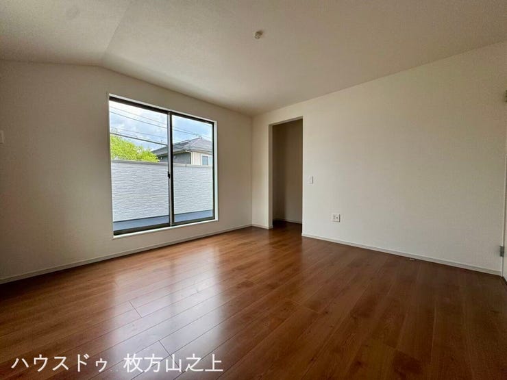 明るく開放的な洋室。大きな窓から心地よい光が差し込み、ゆったりとくつろげる空間です。