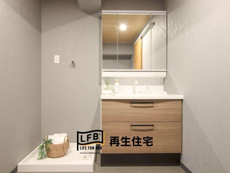 洗面台交換しました。三面鏡で身支度がしやすいです。収納部分は木目調になっており、手前の引き戸と雰囲気が合っています。