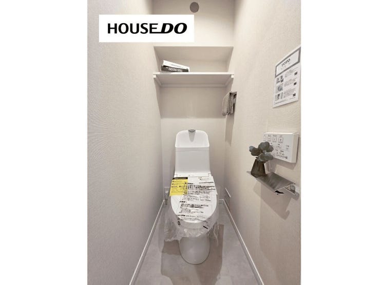 清潔感のあるトイレ空間。上部棚付きでストック類の収納にも便利です。