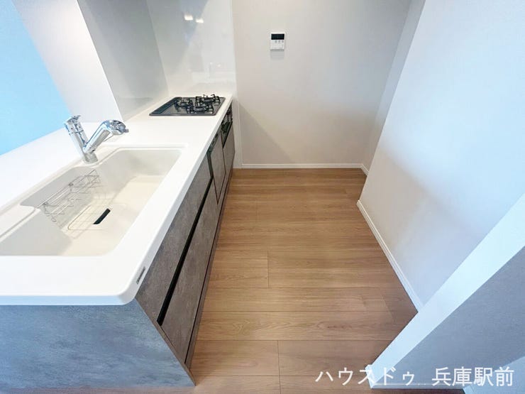 3口コンロと食洗機を備えた、機能性の高いシステムキッチンです。作業スペースも確保された使いやすいレイアウトで、調理・片付けの動線がスムーズ。