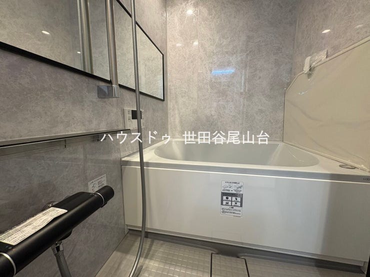 グレーを基調とした上質感のあるバスルーム。ゆったりとした浴槽に加え、大きな横長ミラーや収納棚を備えた、落ち着きのある空間です。